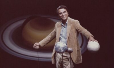 Carl Sagan no set do programa de televisão Cosmos, com um modelo planetário, 1981