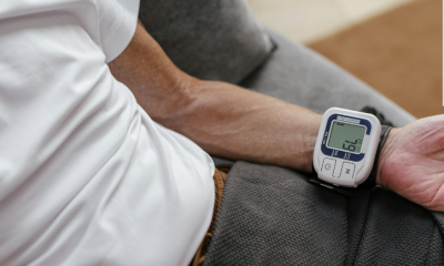 Medidor digital de pressão arterial de pulso, exibindo a respetiva leitura da pressão arterial.