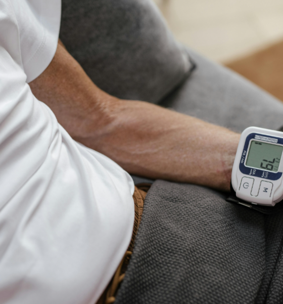 Medidor digital de pressão arterial de pulso, exibindo a respetiva leitura da pressão arterial.