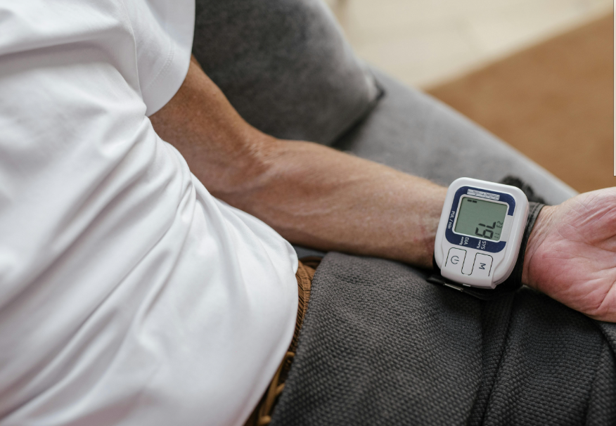 Medidor digital de pressão arterial de pulso, exibindo a respetiva leitura da pressão arterial.